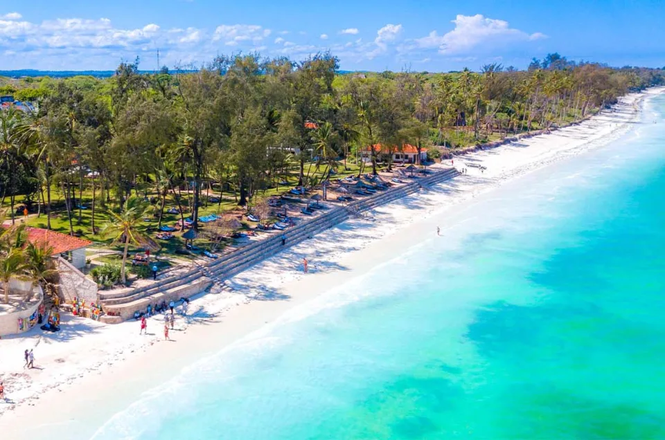 Diani Beach: Aerial view of white sand beach, turquoise water, palm trees, and coastal resorts.