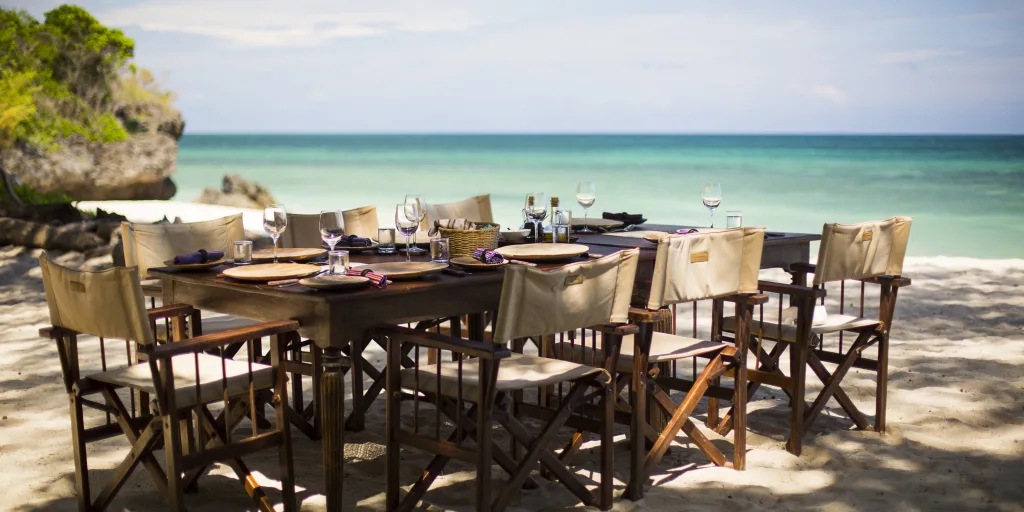 Beach dining at Diani Beach: Table set on the sand with ocean view.
