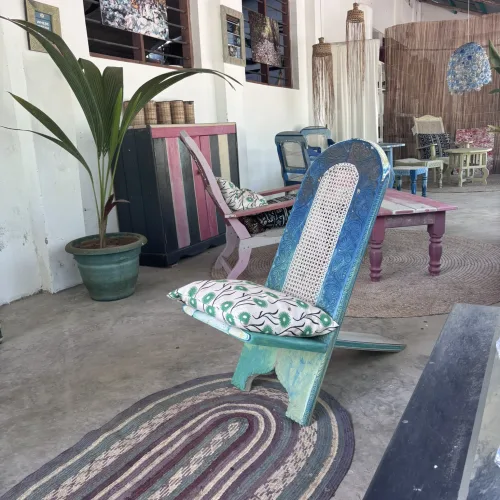 Colorful wooden chairs and decor in a cozy coastal lounge with Swahili-inspired interior design